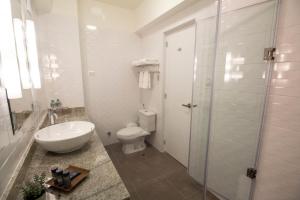 皮乌拉Tierra Viva Piura Hotel的带马桶和水槽的白色浴室