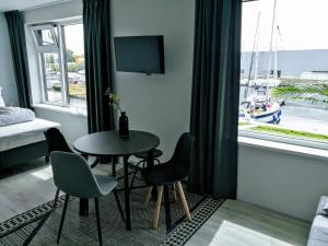 レンメルにあるMarina Strand Appartement Lemmerのテーブルと椅子、窓が備わる客室です。