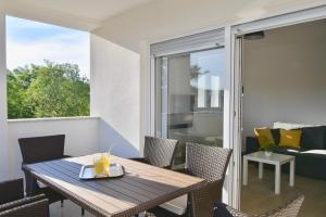 Un balcón con una mesa y sillas y un sofá. en Apartments Mira, en Pula