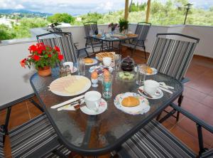 einen Tisch mit Speisen auf dem Balkon in der Unterkunft Corfu Room in Áyioi Dhéka