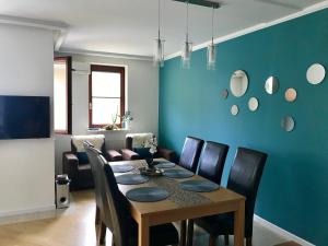 a dining room with a table and a blue wall at Stadium Apart in Warsaw