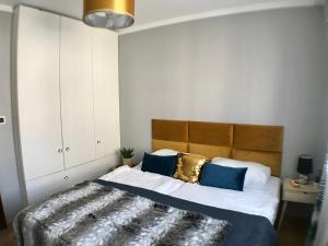 a bedroom with a large bed with blue and gold pillows at Stadium Apart in Warsaw +36 photos