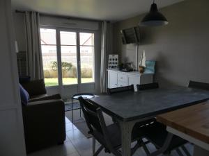 a living room with a table and chairs and a window at Au gré du vent in Camiers