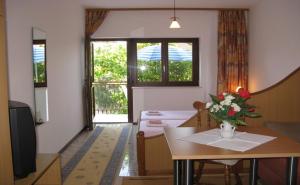 ein Wohnzimmer mit einem Tisch und einer Blumenvase darauf in der Unterkunft Apartments Miho in Orebić