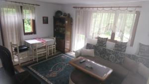 een woonkamer met een bank en een tafel bij Cottage Forest Stream in Visoko