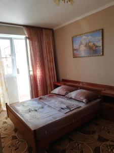 a bedroom with a bed with a picture on the wall at Elena Apartment in Pizunda