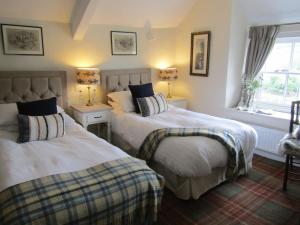 a bedroom with two beds and a window at The Rising Sun in Umberleigh Bridge