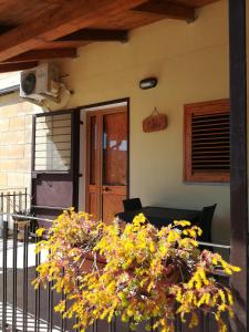 une terrasse couverte d'une maison avec une table et des fleurs dans l'établissement Il Terrazzo Sul Sinni, à Rotondella