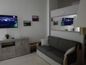 uma sala de estar com um sofá e uma televisão de ecrã plano em Rogoredo Milan Apartments em Milão