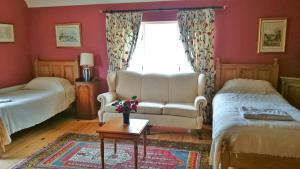 a living room with a couch and a bed and a window at Kilmokea Coach House in New Ross