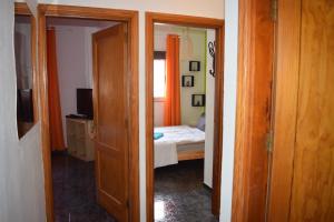 a room with a bedroom with a bed and an open door at B&B La Caleta Zimmer 2 in La Mareta