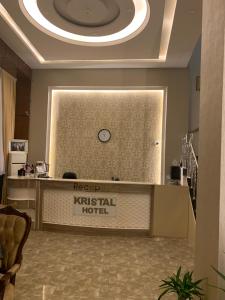 a reception desk in a hotel with a clock on the wall at Kristal Hotel Duhok in Duhok