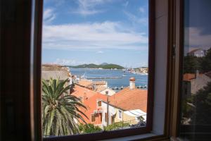 une fenêtre avec vue sur l'eau et les bâtiments dans l'établissement BUGA apartment in center of Mali Losinj, à Mali Lošinj