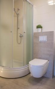 La salle de bains est pourvue d'une douche, de toilettes et d'une baignoire. dans l'établissement BUGA apartment in center of Mali Losinj, à Mali Lošinj