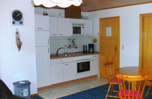 a kitchen with white cabinets and a table with a sink at Stöckmann in Neuenkirchen