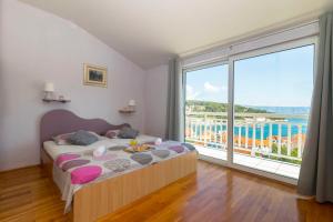 Un dormitorio con una cama y una ventana grande. en Apartments Palma, en Jelsa