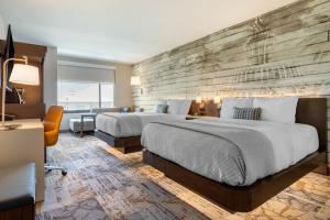 Cambria Hotel Charleston Riverview tesisinde bir odada yatak veya yataklar