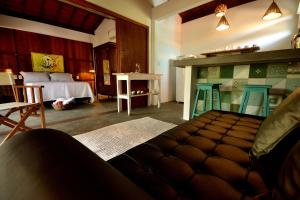 a living room with a bed and a table and chairs at Boa Village- Bungalow com Piscina Natural- Praia de Algodões in Marau