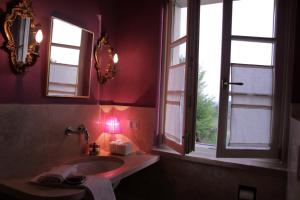 un bagno con lavandino e due finestre di Casa Soleluna B&B a Cortona