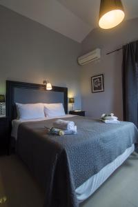a bedroom with a large bed with a blue blanket at Villa Elaia Suites & Apartments No.1 in Gaios