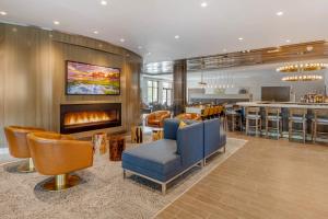 a hotel lobby with a fireplace and a bar at Cambria Hotel Charleston Riverview in Charleston
