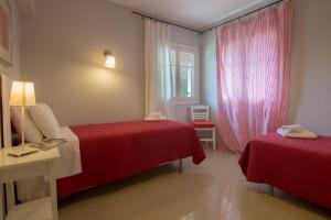 a hotel room with two beds and a window at Villa Elaia Suites & Apartments No.2 in Gaios