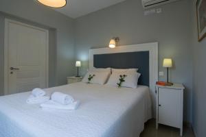 a bedroom with a white bed with towels on it at Villa Elaia Suites & Apartments No.2 in Gaios