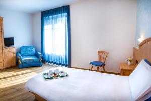 Una habitación de hotel con una cama con una bandeja de comida. en Agritur Val d'Adige, en Trento