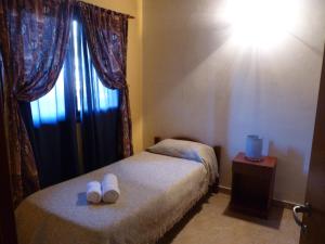 a small bedroom with two beds and a window at Cabañas de los Comechingones in Merlo