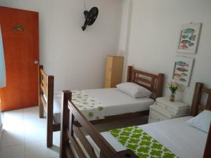 Hostal Palohe Taganga في تاجانجا: غرفة بسريرين في غرفة