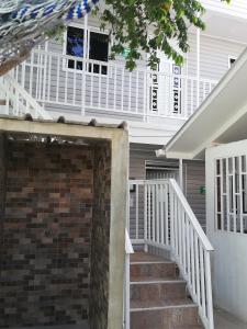 a stairway leading to a home with a white porch at Rocky Cay Lodging in San Andrés