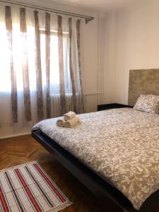 - une chambre avec un lit et une fenêtre avec des rideaux dans l'établissement Blue Apartment, à Drobeta-Turnu Severin