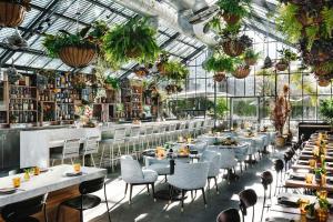 a restaurant with tables and chairs in a greenhouse at The LINE Hotel LA in Los Angeles