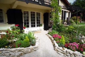 a garden in front of a house with flowers at Escapades Romantiques Uniques amour amour amour in Loubès-Bernac