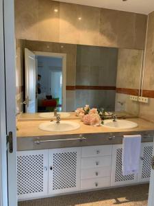 a bathroom with two sinks and a large mirror at Chalet con piscina a 50 m de la playa . in Marbella
