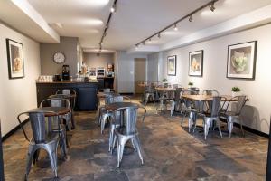 um restaurante com mesas e cadeiras num quarto em SureStay Hotel by Best Western Castlegar em Castlegar
