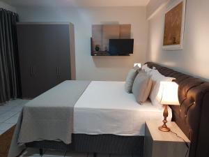 a bedroom with a large bed and a lamp at B & A Suites Inn Hotel - Quarto Luxo Diamond in Anápolis