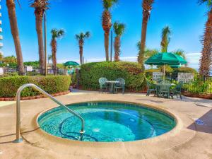 - une petite piscine avec une table, des chaises et des palmiers dans l'établissement Romantic Oceanfront View, Discounted, Pools, à Myrtle Beach