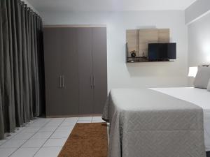 a bedroom with a bed and a cabinet and a television at B & A Suites Inn Hotel - Quarto Luxo Diamond in Anápolis