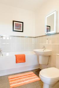 a bathroom with a tub and a toilet and a sink at Camstay Townhouse in Cambridge