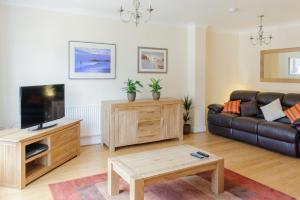 a living room with a couch and a tv at Camstay Townhouse in Cambridge