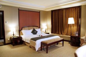 um quarto de hotel com uma cama e uma grande janela em The Royal Marina Plaza Hotel Guangzhou em Guangzhou