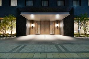 uma entrada para um edifício com uma grande porta de madeira em Vessel Hotel Campana Susukino em Sapporo