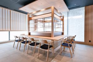 a dining room with a wooden table and chairs at Vessel Hotel Campana Susukino in Sapporo