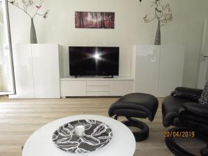 sala de estar con TV, mesa y sillas en Fewo Am Wald 5, en Hahnenklee-Bockswiese