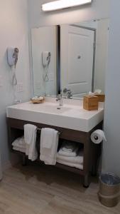 uma casa de banho com lavatório, espelho e toalhas em Lakes Inn at Dunvilla em Dunvilla