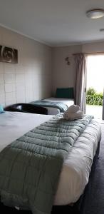 a bedroom with two beds and a window at Mokau Motels in Mokau