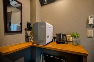 a microwave sitting on top of a counter in a kitchen at IKIDANE Residential Hotel Komagome in Tokyo