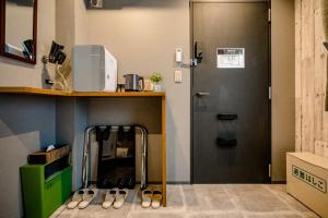 Zimmer mit einer Tür und einem Tisch mit Schuhen in der Unterkunft IKIDANE Residential Hotel Komagome in Tokio