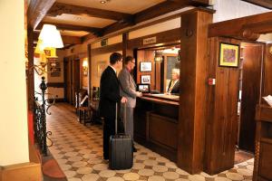 two men standing at a bar with a suitcase at Hotel Restaurant Höttche in Dormagen